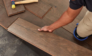 Professional flooring installer laying new plank flooring